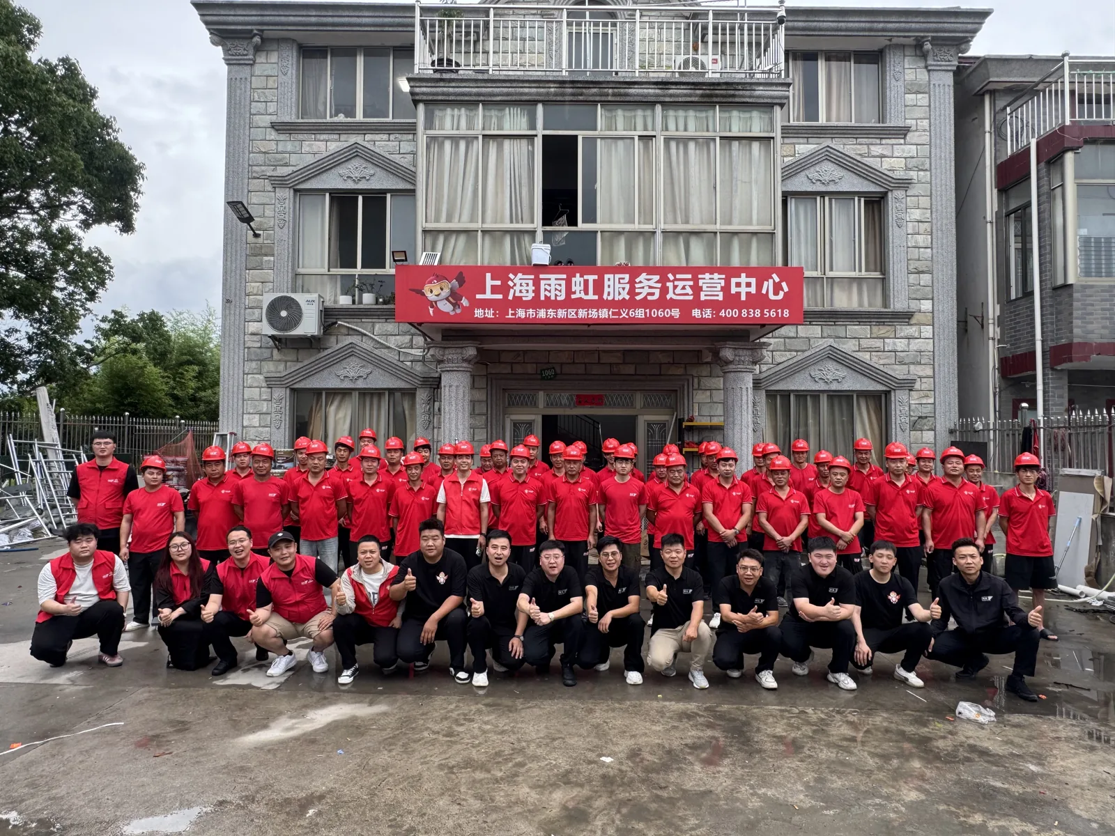 齐泰众成提供的服务团队合影,队员身着红色工作服在培训中心前合照